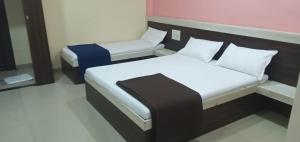 a small bedroom with a bed and a chair at Hotel SS Palace in Shirdi