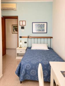 a bedroom with a bed with a blue comforter at Hotel Mazzocca in Caramanico Terme