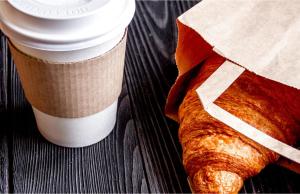 a cup of coffee and a croissant on a table at Americas Best Value Inn Irving DFW Airport South in Irving +29 photos