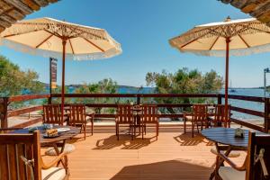 eine Terrasse mit Tischen, Stühlen und Sonnenschirmen in der Unterkunft Brazzera Hotel in Finikas + 92 Fotos