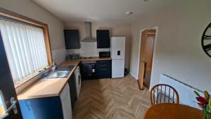 a kitchen with a sink and a refrigerator at Firthview Golspie in Golspie