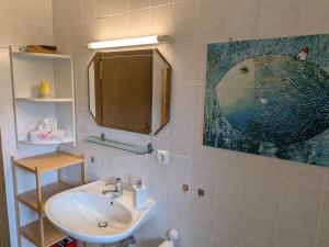 a bathroom with a sink and a painting on the wall at Ferienwohnung Straußstrasse in Bayerisch Gmain