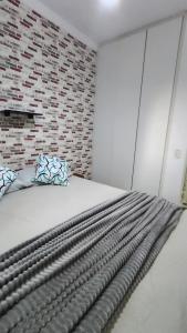 a bed in a room with a brick wall at Dois quartos mobiliado próximo a praia in Vila Velha