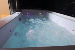 a bath tub filled with blue water at Hotel House in Rishon LeẔiyyon