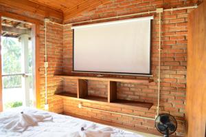 a brick wall with a flat screen tv on a wall at Pousada Alto Pirapitinga in Resende