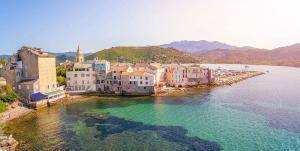 a group of buildings on the shore of a body of water at Alta Suarella in Saint-Florent