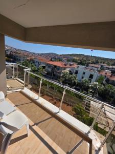 a balcony with a white chair and a view of a city at Atlas Apart Hotel in Çeşme