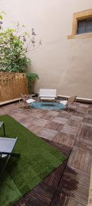 a patio with two benches and grass at La terrasse du palais in Metz