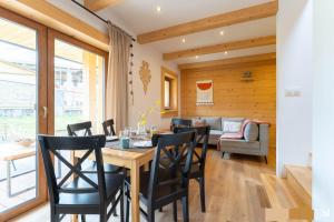 a dining room with a table and chairs and a couch at Heidi in Zakopane