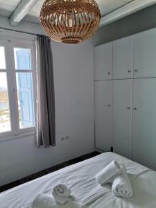 a bedroom with a bed with towels and a chandelier at Flora's House in Livadakia