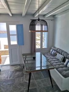 a living room with a couch and a glass table at Flora's House in Livadakia