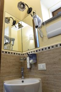 a bathroom with a mirror and a sink at Palazzo Collegiata Rooms & Suite in Monreale +42 photos