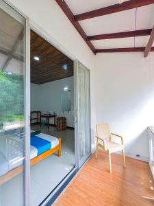 a room with a bed and a chair and a window at Nandana Homestay in Udawalawe