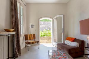 a living room with a couch and a window at Mas de charme - T2 et chambres d'hôtes avec piscine & jardin in Marsillargues