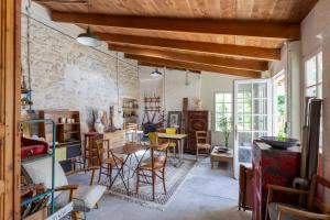 a room with chairs and tables and a stone wall at Mas de charme - T2 et chambres d'hôtes avec piscine & jardin in Marsillargues