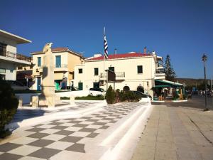 a large white building with a checkered street at Characterful 2-Bed Home in Peaceful Town Near Agios Nikolaos in Neápolis