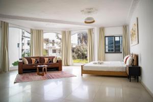 a bedroom with a bed and a couch and a large window at Francesca Guest House in Dakar +112 photos
