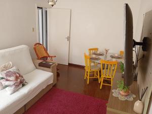 a living room with a white couch and a table at Conforto no Centro in Pelotas