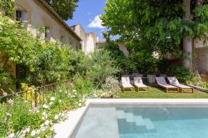 a backyard with a swimming pool and chairs and trees at Mas de charme - T2 et chambres d'hôtes avec piscine & jardin in Marsillargues