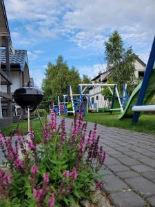 a park with a playground with slides and flowers at Szum Fal in Rusinowo
