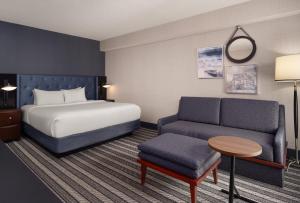 a hotel room with a bed and a couch at Courtyard by Marriott Boston Brookline in Brookline