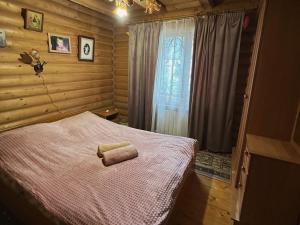 a bedroom with a bed with a towel on it at Teremok in Tatariv