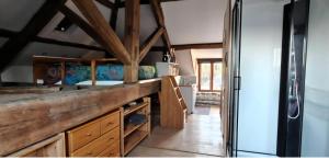 a kitchen with wooden cabinets and a refrigerator at Studio in Bruyères-le-Châtel