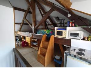 a kitchen with a stove and a microwave at Studio in Bruyères-le-Châtel +4 photos