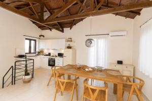 a large kitchen with a wooden table and chairs at Villa Metochi in Skala