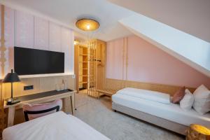 a hotel room with two beds and a flat screen tv at Hotel Schäfflerwirt in Aschheim