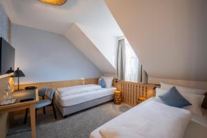 a attic room with two beds and a couch at Hotel Schäfflerwirt in Aschheim