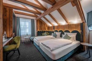 a bedroom with two beds in a room with wooden walls at Hotel Schäfflerwirt in Aschheim