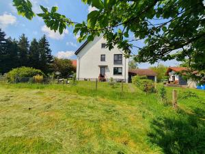 a white house on top of a grassy field at Landliebe in Blomberg