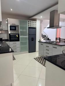 a large kitchen with white tile floors and appliances at Casa Amélia in Cidade Velha