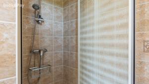 a shower with a glass door in a bathroom at Eugénie in Saint-Quentin-de-Chalais