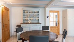 a dining room with a wooden table and chairs at Eugénie in Saint-Quentin-de-Chalais