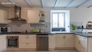 a kitchen with white cabinets and a sink at Eugénie in Saint-Quentin-de-Chalais +6 photos
