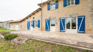 a brick building with blue doors and windows at Eugénie in Saint-Quentin-de-Chalais