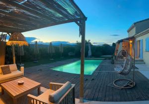 a backyard with a pool and a wooden deck with a table at Maison dans la Drôme Piscine privée in Montélimar