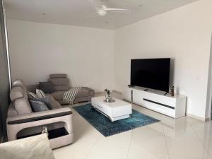 a living room with a couch and a flat screen tv at Casa Amélia in Cidade Velha