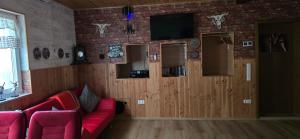 a living room with a red couch and a tv at Ferienwohnung Ilka's Lodge in Michelstadt