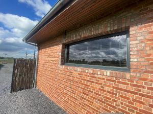 a brick wall with a window on the side of a building at La Gazolina in Boeseghem
