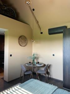 a dining room with a table and chairs and a clock at La Gazolina in Boeseghem