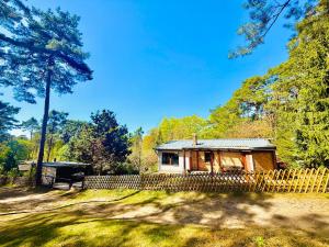 a small cabin in the woods with a fence at Nature Bungalow in Ferch in Schwielowsee