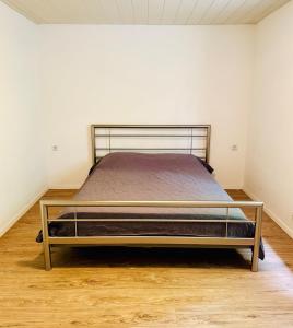 a large bed in a room with a wooden floor at Nature Bungalow in Ferch in Schwielowsee