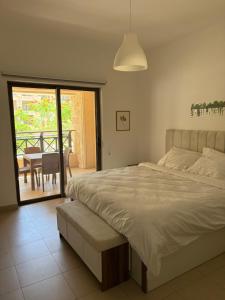 a bedroom with a bed and a table and a balcony at Samara in Sowayma +17 photos