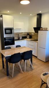 a kitchen with a wooden table and white appliances at Escapade cosy proche nature in Saint Die