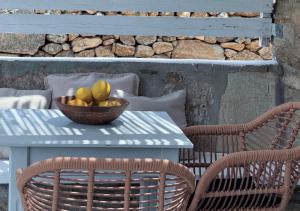 a bowl of fruit on a table with two chairs at Aloni Ios in Mylopotas
