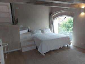 a bedroom with a bed and a large window at Fairytale old stonehouse in Brendola