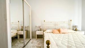 a bedroom with a large bed and a mirror at Castelsardo Appartment in Castelsardo